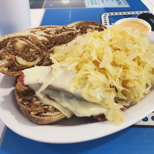 A Southside Diner Reuben sandwich on marble rye with melted cheese and a generous topping of sauerkraut.