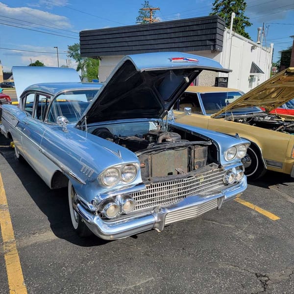 A light blue vintage car with its hood open, parked in front of the Southside Diner.