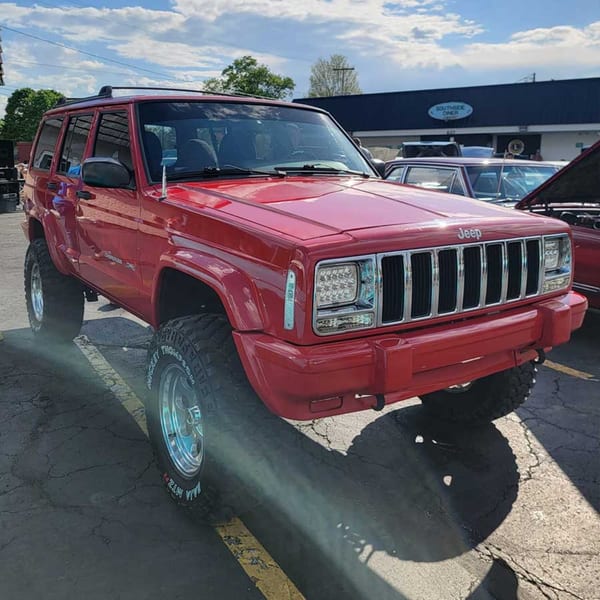 A bright red Jeep Cherokee with large tires parked outside the Southside Diner.